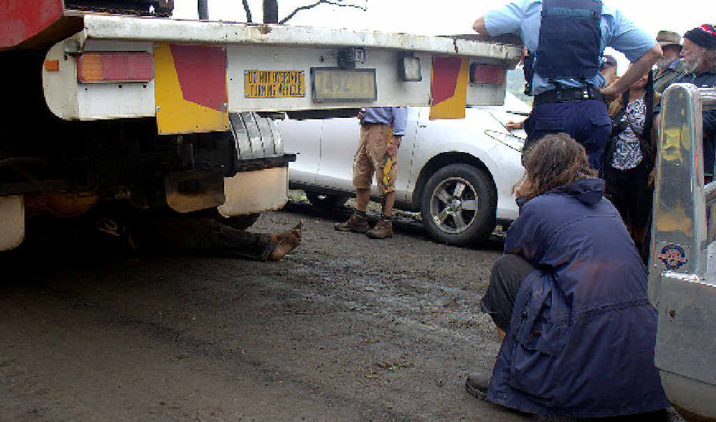 Protesters watch as protester Gareth Devenish of Mullumbimby lies locked under a truck at Doubtful Creek. Protesters watch as protester Gareth Devenish of Mullumbimby lies locked under a truck at Doubtful Creek.